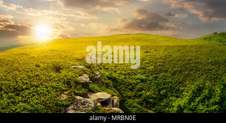 Panorama der Hügel Wiese bei Sonnenuntergang. schönen Sommer Landschaft mit Felsen unter dem Gras. Standort Runa Berg, Ukraine Stockfoto