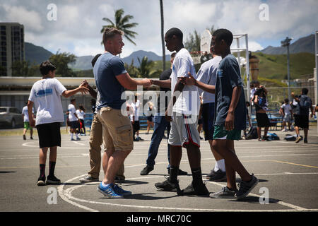 KAILUA, Hawaii - Lance Cpl. Malsky Kennan, einem Masse Elektronik Telekommunikation und Informationstechnologie Betreuer mit Sitz Bataillon, Marine Corps Base Hawaii, beglückwünscht die Schüler nach ein Basketball Spiel bei Kailua Mittelschule, 12. April 2017. Marines gab zurück zu ihrer Gemeinschaft durch Freiwilligenarbeit an KIS für die Schule" Mittwoch Volunteer Programm." Das Programm bietet Marines die Möglichkeit, mit den Studierenden zu interagieren, unterstützen die Lehrer im Klassenzimmer, und positive Vorbilder für die Kinder. Stockfoto