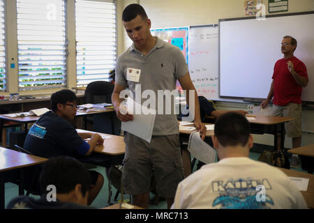 KAILUA, Hawaii - Lance Cpl. Harrison Acosta, eine Masse Elektronik technische Systeme Betreuer mit Sitz Bataillon, Marine Corps Base Hawaii, Pässe, Arbeitsblätter in Kailua Mittelschule, 12. April 2017. Marines gab zurück zu ihrer Gemeinschaft durch Freiwilligenarbeit an KIS für die Schule" Mittwoch Volunteer Programm." Das Programm bietet Marines die Möglichkeit, mit den Studierenden zu interagieren, unterstützen die Lehrer im Klassenzimmer, und positive Vorbilder für die Kinder. Stockfoto