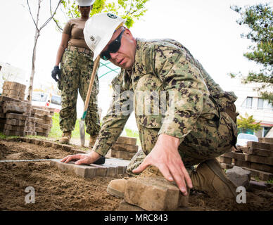 POHANG, Republik Korea (14. April 2017) - Chief Steelworker John White, der Amphibischen Bau Bataillon (ACB) 1 zeigt die richtige Maurer an einer lokalen Rehabilitation Center angeschlossen. ACB1 ist in Betrieb Pazifik erreichen Übung 2017 ein bilaterales Schulungsveranstaltung entwickelt, Bereitschaft zu gewährleisten und die ROK-U.S. sustain Allianz durch die Ausübung einer Bereich Distribution Center (ADC), ein Air Terminal Stromanschluss (Atsp), Kombinierte Joint Logistics Über das Ufer (CJLOTS) und der Nutzung der Schiene, Binnenwasserstraßen, und heben Sie die Küste, die für die operative erreichen Konzept zu validieren. Stockfoto