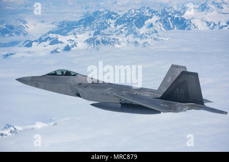 Eine F-22 Raptor aus dem 3 Flügel, US Air Force Reserven, begleitet die 176 Flügel, Alaska Air National Guard's neu HC-130J "Combat König II"-Flugzeuge, die auf der Rückreise zu Joint Base Elmendorf-Richardson, Alaska, 3. Juni erworben. Zwei Raptors waren Ausbildung für eine Intercept Mission in der Gegend, wenn Sie die Gelegenheit wahr, sich zu "Abfangen" der HC-130J in Verbindung mit ihrer Ausbildung Anforderungen, und dann der Kampf gegen König II mit einer Eskorte zurück zu JBER. (U.S. Air National Guard Foto: Staff Sgt. Edward Eagerton/freigegeben) Stockfoto