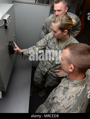 Us-Staff Sgt. Ariel Shannon, 88th Sicherheitskräfte Squadron Pläne und Programme Unteroffizier, Eingänge einen PIN-Code, während Air Force Tech Sgt Matthew Gillette, 88th SFS elektronische Systeme Unteroffizier und Staff Sgt. James Glas, 88th SFS physische Sicherheit NCOIC beobachten, als Teil der Alarm System Ausbildung bei der wright-patterson Air Force Base, Ohio, 16. Mai 2017. Die 88 SFS monitor Alarm Systeme und helfen, Gebäude hausmeister Eingang PIN-Codes richtig. (U.S. Air Force Foto/Michelle Gigante) Stockfoto