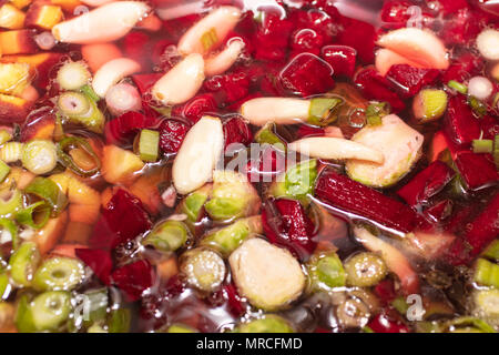 Pflanzliche Rohstoffe zerkleinert und in Brühe platziert Suppe zu machen Stockfoto