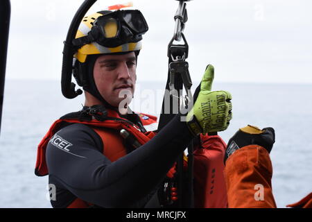 Petty Officer 2nd class Lyman Dickinson, einer Luftfahrt überleben Techniker an der Coast Guard Sektor San Diego, bereitet sich für eine Hebevorrichtung an Bord einer MH-60 Jayhawk Helikopter bei einer gemeinsamen Suche und Rettung Übung mit der mexikanischen Marine vor der Küste von Ensenada, Mexiko am 7. Juni 2017. Die Übung simulierte ein Schiff, das Feuer, das eine koordinierte internationale Such- und Rettungsaktionen erforderlich. (U.S. Coast Guard Foto von Petty Officer 3. Klasse Joel Guzman) Stockfoto