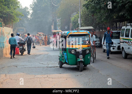 Delhi, Indien - 20. November 2015: Bunte Tuk-Tuk Fahrzeuge und Fußgänger in einem überfüllten Verkehr von Delhi mit sichtbaren smog Luftverschmutzung Stockfoto