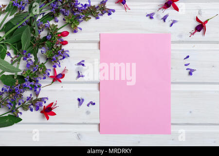 Weiße Tischplatte mit Frühling Blumen und Leere rosa Papier Stockfoto