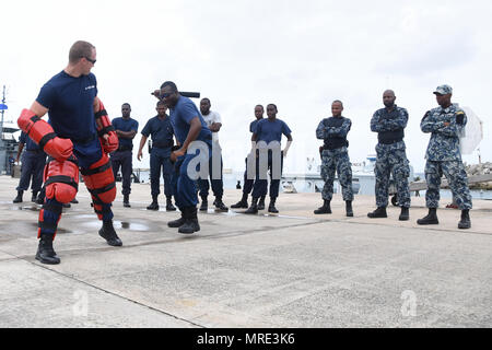 Coast Guard Petty Officer 1st Class Brett Doherty, einen maritimen Durchsetzung Spezialist, gibt der Schulung im Bereich Strafverfolgung auf Partner nation Teilnehmer der Tradewinds 2017 Barbados Coast Guard Base in Bridgetown, Barbados, 9. Juni 2017. Tradewinds 2017 ist eine gemeinsame, kombinierte Übung in Verbindung mit Partnerstaaten durchgeführt, um die kollektiven Fähigkeiten der Streitkräfte und constabularies transnationale organisierte Kriminalität zu verbessern und humanitäre/Katastrophenhilfemaßnahmen zu führen. (U.S. Coast Guard Foto von Petty Officer 1st Class Melissa Leake/Freigegeben) Stockfoto