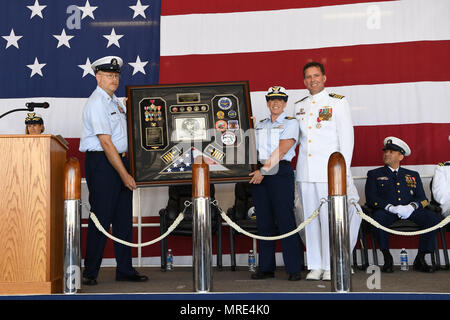 Coast Guard Master Chief Petty Officer Daniel Kelly und Lt.Cmdr. Ally M. Thompson vorhanden Kapitän Richard Craig mit Schatten, während seiner Pensionierung Zeremonie an der Coast Guard Air Station Elizabeth City, North Carolina, Juni 09, 2017. Craig in den Ruhestand nach fast 27 Jahren in der Küstenwache und drehte das Kommando der Air Station Elizabeth City während der Zeremonie. Die US-amerikanischen Coast Guard Foto von Aux. David Lau Stockfoto