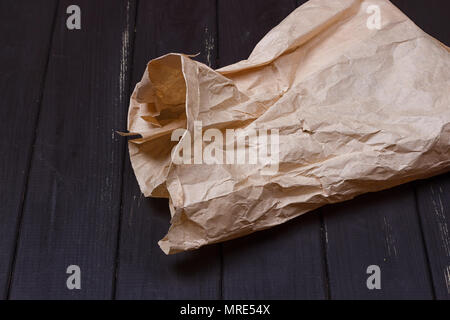 Ein Beutel mit Kraftpapier auf schwarzem Hintergrund Stockfoto
