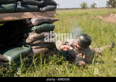 Der Soldat mit der Ukraine 1 Airmobile Bataillon, 79 Air Assault Brigade wirft eine Granate in einen Bunker während Platoon Bewegung und Angriff bohrt mit der yavoriv Combat Training Center. Yavoriv CTC Personal, zusammen mit Mentoren aus 45Th der US Army Infantry Brigade Combat Team, führte die Ausbildung von Soldaten aus dem 1-79 Th während der Drehung des Bataillon durch die YAVORIV CTC. Der 45. ist in der Ukraine als Teil des Gemeinsamen multinationalen Ausbildung Group-Ukraine, eine internationale Koalition für eine Verbesserung der Ausbildung der Fähigkeit des CTC und Professionalität in der Ukr bereitgestellt Stockfoto