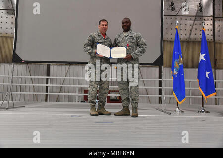 Generalmajor Christopher Bence, Luftwaffe Expeditionary Center Commander, stellt Oberst Rodney Lewis, 319 Air Base Wing Commander, mit der Legion des Verdienstes auf Grand Forks Air Force Base, N.D., 14. April 2017. Lewis wich von Grand Forks AFB und ist Direktor des Executive Action Group für die Luftwaffe Stabschef im Pentagon. Stockfoto