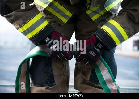 Ein 35Th Bauingenieur Squadron Feuerwehrmann verbindet zwei feuerlöschschläuchen vor einem Burn gesteuert von einem Gebäude in Misawa Air Base, Japan, 15. März 2017. Die Schläuche wurden strategisch vor dem Gebäude für den Fall, dass das Feuer außer Kontrolle geriet. Feuerwehrmänner bieten Programme und Dienstleistungen, die Leben und Eigentum der Bewohner und Besucher von Misawa AB zu schützen. Sie bilden sowohl lokale als auch globale Missionen zu erfüllen. (U.S. Air Force Foto: Staff Sgt. Melanie Hutto) Stockfoto