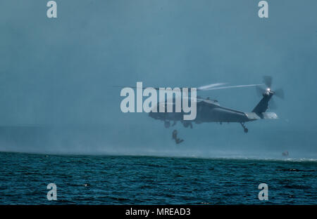 Marine Special Operations Schule Individuelle Schulung Studenten helocast von einem US-Marine SH-60 Seahawk Hubschrauber, 23. März 2017, im Key West, Fla. Zum ersten Mal, US Air Force Special Taktik Flieger drei Monate im ersten Marine Special Operations Command Marine Raider Ausbildung Pipeline ausgegeben, die Bemühungen um gemeinsame Denkweisen über Special Operations Forces zu errichten. (U.S. Air Force Foto von älteren Flieger Ryan Conroy) Stockfoto