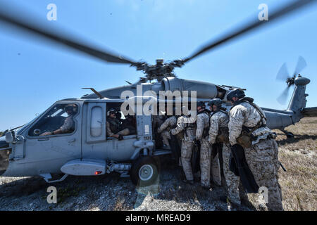 Marine Special Operations Schule Individuelle Schulung Studenten Last auf einem US-Marine SH-60 Seahawk Hubschrauber für helocasting Training, 23. März 2017, im Key West, Fla. Zum ersten Mal, US Air Force Special Taktik Flieger drei Monate im ersten Marine Special Operations Command Marine Raider Ausbildung Pipeline ausgegeben, die Bemühungen um gemeinsame Denkweisen über Special Operations Forces zu errichten. (U.S. Air Force Foto von älteren Flieger Ryan Conroy) Stockfoto