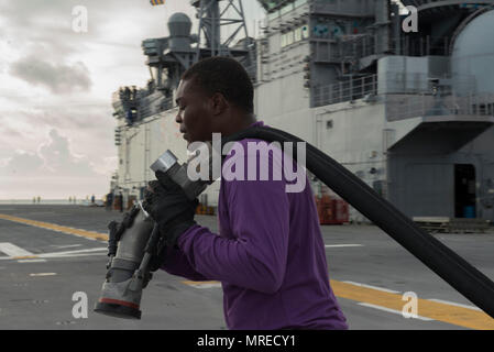 MAYPORT, Fla (11. Juni 2017) der Luftfahrt Bootsmann Mate (Kraftstoff) Airman Kenneth Kountz bereitet einen Schlauch für den Flugbetrieb auf dem Flugdeck des Amphibious Assault ship USS Iwo Jima (LHD7). Iwo Jima befindet sich derzeit in einer Reihe von Zertifizierungen in Vorbereitung für künftige Operationen und Bereitstellungen. (U.S. Marine Foto von Mass Communication Specialist Seaman Kevin Leitner/Freigegeben) Stockfoto