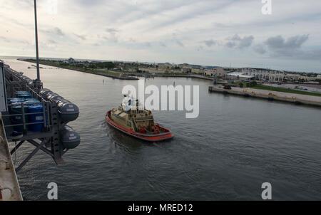 MAYPORT, Fla (11. Juni 2017) eine Tug Boat unterstützt die Amphibious Assault ship USS Iwo Jima (LHD7), als sie aus ihrem Heimathafen zieht an Naval Station Mayport. Iwo Jima befindet sich derzeit in einer Reihe von Zertifizierungen in Vorbereitung für künftige Operationen und Bereitstellungen. (U.S. Marine Foto von Mass Communication Specialist Seaman Kevin Leitner/Freigegeben) Stockfoto