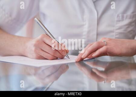 Weibliche osteopath Notizen zu machen, in der Nähe auf. Stockfoto