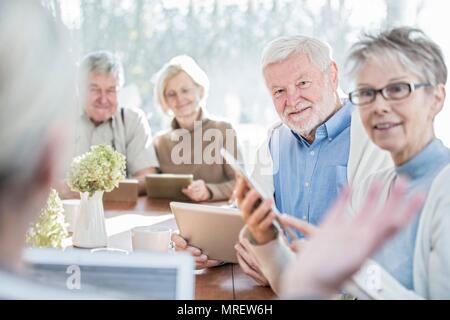 Ältere Erwachsene in der Pflege zu Hause mit digitalen Tabletten. Stockfoto