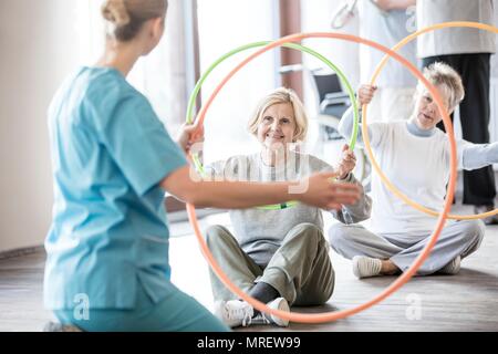 Physiotherapeutin mit zwei ältere Frauen, die sich in Kunststoff Bänder. Stockfoto