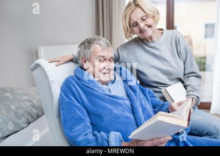 Senior Paar lesen Buch in der Pflege zu Hause. Stockfoto