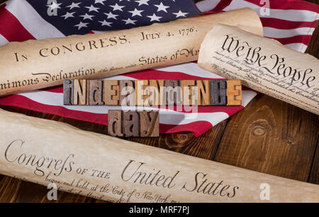 "Independence Day" Banner mit hölzernen Briefe mit der Erklärung der Unabhängigkeit, der US-Verfassung und der Menschenrechte, und United Flaggenstaaten Stockfoto