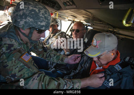 Us-Armee Oberstleutnant Steven Sewell mit Joint Force Head Quarters, South Dakota Army National Guard unterstützt Lawrence Weiss Mitglied der South Dakota der militärischen Angelegenheiten, die mit dem Kabelbaum der ein HH-60 M MEDEVAC Black Hawk während des goldenen Coyote Übung in Rapid City, S.D., 15. Juni 2017. Die goldenen Coyote Übung ist eine dreiphasige, Szenario-driven Übung in den Black Hills von South Dakota und Wyoming, mit dem Kommandanten auf der Mission wesentliche Anforderungen der Aufgabe, Krieger Aufgaben und Übungen zu konzentrieren. (U.S. Armee Foto von SPC. Kevin Kim) Stockfoto