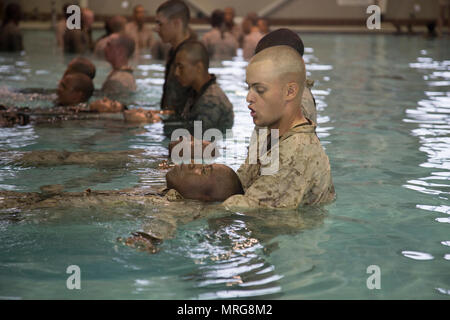 Us Marine Corps Rekruten, Alpha Company, 1.BATAILLON, rekrutieren Training Regiment, unterstützen sich gegenseitig mit der richtigen Schwimmen Techniken bei der Bekämpfung der Ausbildung Pool auf Marine Corps Depot rekrutieren, Parris Island, S.C., 13. Juni 2017. Nach Demonstrationen, Rekruten auf ihre Fähigkeit im tiefen Wasser zu springen, die richtige Ausrüstung Halle getestet und Wasser treten in voller Dienstprogramme als Teil ihrer Qualifizierung schwimmen. (U.S. Marine Corps Foto von Lance Cpl. Sarah Stegall/Freigegeben) Stockfoto