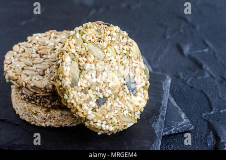 Gesunde Desserts Müsli Snacks. Fitness Ernährung super Essen. Kozinaki mit Sesam, Flachs, Erdnüsse, Sonnenblumenkerne und kürbiskerne am Schiefer Platte. Vegetar Stockfoto