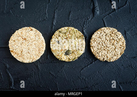 Hausgemachtes Müsli Snacks. Fitness Ernährung super Essen. Drei kozinaki mit Sesam, Flachs, Erdnüsse, Sonnenblumenkerne und kürbiskerne am Schiefer Platte. Vegan h Stockfoto