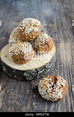 Süße nachspeise Müsli Snacks. Fitness diätetische Lebensmittel. Banane - Haferflocken Cookies mit Honig und Sesam bestreut auf hölzernen runden Sockel an der alten Rost Stockfoto