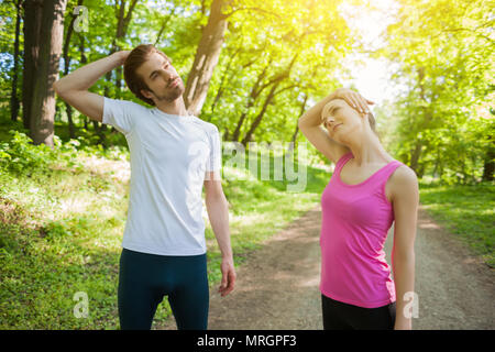 Paar ist das Trainieren im Park. Sie sind stretching Körper. Stockfoto