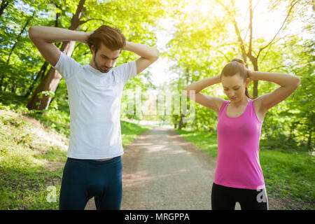 Paar ist das Trainieren im Park. Sie sind stretching Körper. Stockfoto