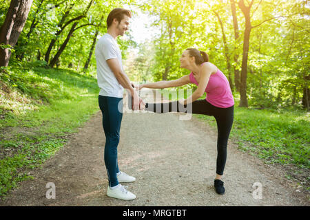 Paar ist das Trainieren im Park. Sie sind stretching Körper. Stockfoto