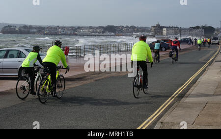 Radfahrer reiten entlang der Küste von Paignton während einer stürmischen Flut. Stockfoto