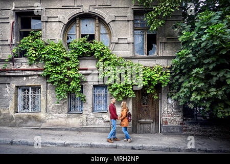 Glückliches Paar der Tourist in der Nähe von Vintage House mit runden Fenster in alten Straßen im Zentrum von Tiflis, Georgien Stockfoto