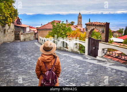 Touristische Frau in Hut mit Rucksack an der Straße von signagi Stadt in Georgien Stockfoto