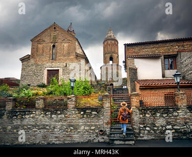 Touristische Frau in Hut mit Rucksack in der Nähe von St. George's Kirche in Signagi Stadt in Georgien Stockfoto