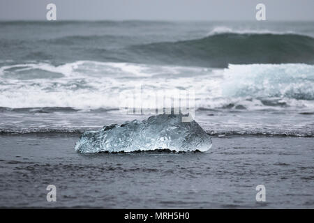 Die Jokulsarlon Gletscherlagune befindet sich bei Breiðamerkurjökull, einem Auslaufgletscher des herrlichen Vatnajökull Gletschers, der dahinter liegt. Eisscholle, Eisschwimmen, Meereis, Drifteis, blaues Eis Eisscholle, Meereisbildung und -Merkmale, schwimmende Eisblöcke, Flöße und Hummocks, eine große Packung schwimmenden Eises am Diamond Beach. Der Jokulsarlon Gletscher, ein treibendes, schwebendes, schmelzendes, wärmendes, Polar, arktisch, global, Gletscher, blau, Kalte, tauende Landschaft, Ozean Lagune schwarzer Sandstrand in Island. Stockfoto