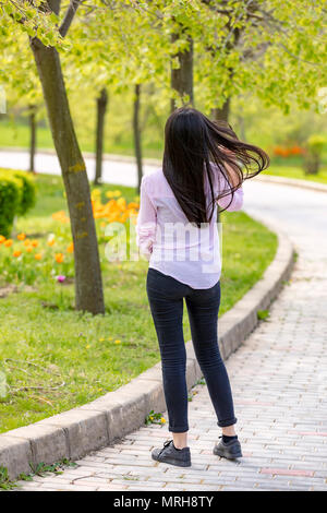 Im freien Porträt der schönen Teenager brunette Mädchen walking im Park Stockfoto