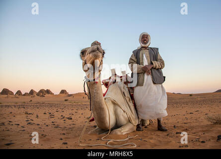 Meroe Pyramiden, Sudan - 19. Dezember 2015: ein Mann mit seinem Kamel in der Wüste Stockfoto