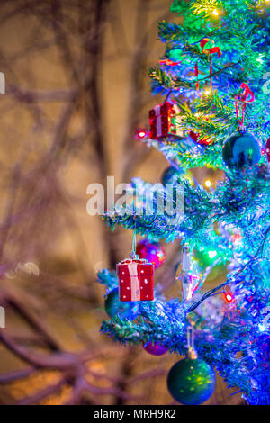 Weihnachtsschmuck auf einem Zweig der Fir, Nacht Idylle, mit Schnee und Lampen in verschiedenen Farben Stockfoto