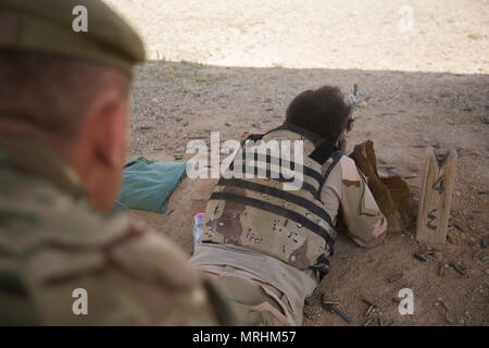 Britische trainer Cpl. Steven, zur Unterstützung von Combined Joint Task Force-Operation inhärenten Lösen bereitgestellt und in den 4 Bataillon Highlanders, Royal Regiment of Scotland zugeordnet, beobachtet eine irakische Soldaten feuern während einer Treffsicherheit Sortiment am Lager Al Asad, Irak, 24. Mai 2017. Diese Schulung ist von entscheidender Bedeutung, damit die lokalen Sicherheitskräfte ihre Heimat von ISIS zu befreien. CJTF-OIR ist die globale Koalition zu besiegen ISIS im Irak und in Syrien. (U.S. Armee Foto von SPC. Cole Erickson) Stockfoto