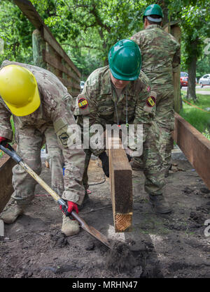 Us-Armee SPC. Chris Leibel (links) mit dem 155 Ingenieur Firma, South Dakota Army National Guard und dänischen Soldaten Lanze Cpl. Stephen Bjerre, 3. Bau Bataillon, Dänische Armee, bereitet ein Stück Holz für eine Fußgängerbrücke während des goldenen Coyote Übung im Custer State Park, Custer, S.D., 16. Juni 2017 festzulegen. Die goldenen Coyote Übung ist eine dreiphasige, Szenario-driven Übung in den Black Hills von South Dakota und Wyoming, mit dem Kommandanten auf der Mission wesentliche Anforderungen der Aufgabe, Krieger Aufgaben und Übungen zu konzentrieren. (U.S. Armee Foto von SPC. Kevin Stockfoto