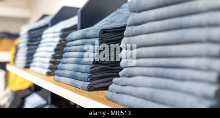 Denim Jeans oder Hose auf einem Regal in einer Boutique Kleidung und Bekleidung Shop oder Shop in Großbritannien Stockfoto