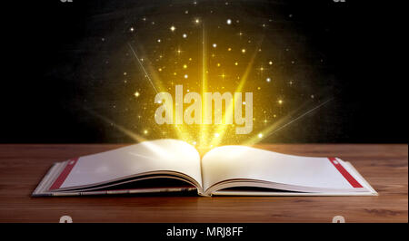 Gelbe Leuchten und Funkeln aus einem offenen Buch Stockfoto