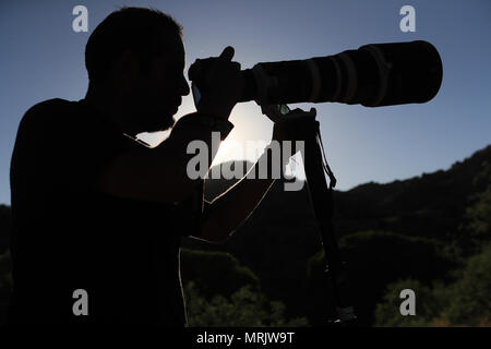 Fotograf Ruben Dario Betancourt verwendet eine 500 mm Canon F4 Objektiv und Sonnenbrille, in Cuenca los Ojos finden. Naturpark,. Sonnenuntergang, Sonne, Sonnenuntergang Stockfoto
