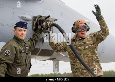 Sgt. Jakob Girardin, eine refueler von E Unternehmen, 3-10 Allgemeine Unterstützung Aviation Battalion, 10 Combat Aviation Brigade, Signale Kraftstoff fließt, eine finnische Luftwaffe F/A-18 Hornet Jet in Lielvarde Air Base, Lettland, am 18. Mai beginnen. Die Düse und Crew erfolgreich abgeschlossen eine Prüfung der Landebahn des Base- und Bremsfunktionen, die Zertifizierung für die Verwendung durch andere NATO-Truppen, die Jets in der Zukunft. (U.S. Armee Foto von SPC. Thomas Scaggs) 170518-A-TZ 475-067 Stockfoto