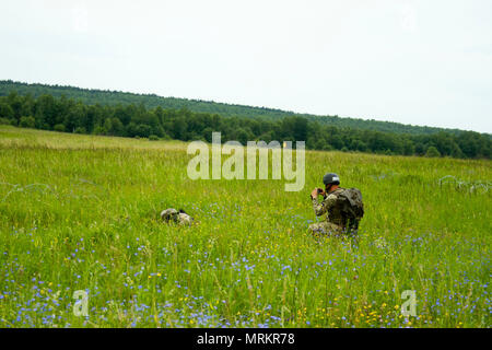 Eine ukrainische Armee Kursleiter auf die yavoriv Combat Training Center zugeordneten Dokumente eine ukrainische Soldaten aus dem 1 Airmobile Bataillon, 79 Air Assault Brigade graben eine defensive Position während der company defence Training am Yavoriv CTC auf der internationalen Friedens und der Sicherheit, in der Nähe der Yavoriv, der Ukraine, der am 22. Juni. Yavoriv CTC Personal, zusammen mit Mentoren aus 45Th der US Army Infantry Brigade Combat Team, führte die Ausbildung von Soldaten aus dem 1-79 Th während der Drehung des Bataillon durch die YAVORIV CTC. Der 45. ist in der Ukraine als Teil des Gemeinsamen Multinationalen bereitgestellt Stockfoto