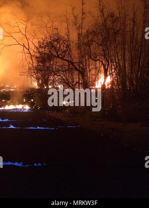 Brände, die durch heiße Gase und flüssige Lava entzündet Methan Gas durch die Straße Risse vom Ausbruch des Kilauea Vulkans am 23. Mai 2018 in Pahoa, Hawaii verursacht. Stockfoto