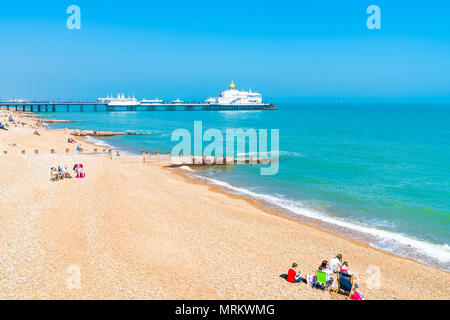 EASTBOURNE, Sussex, UK - Mai 20,2018: Menschen am Strand entspannen in Eastbourne, einem Badeort in East Sussex. Die Küste ist mit viktorianischen Uhr gefüttert Stockfoto